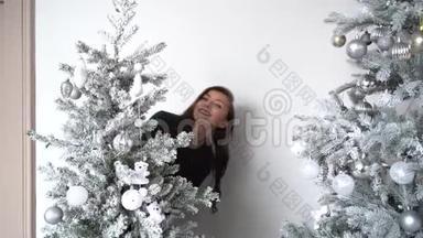一个女人在<strong>圣诞</strong>树背景上穿着裙子微笑的新年画像